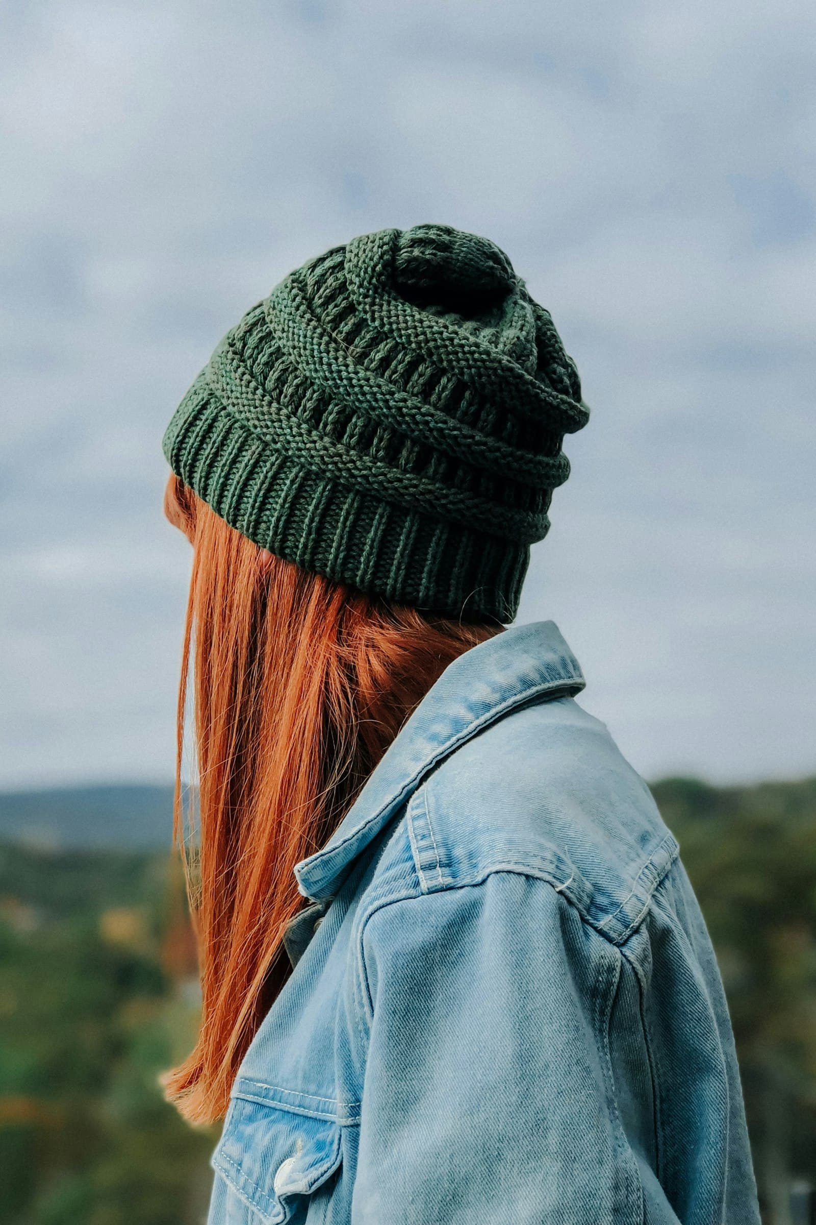 Woman wearing green knit cap and blue denim jacket