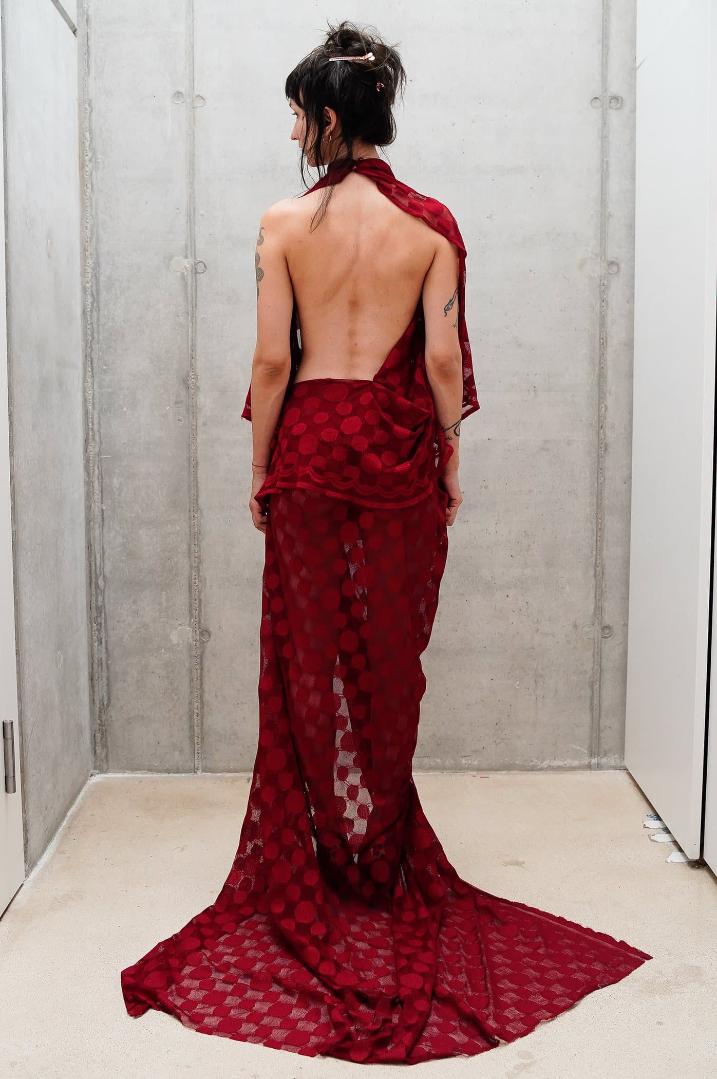 Red sheer check gown, draped at the hip with a pooled train
