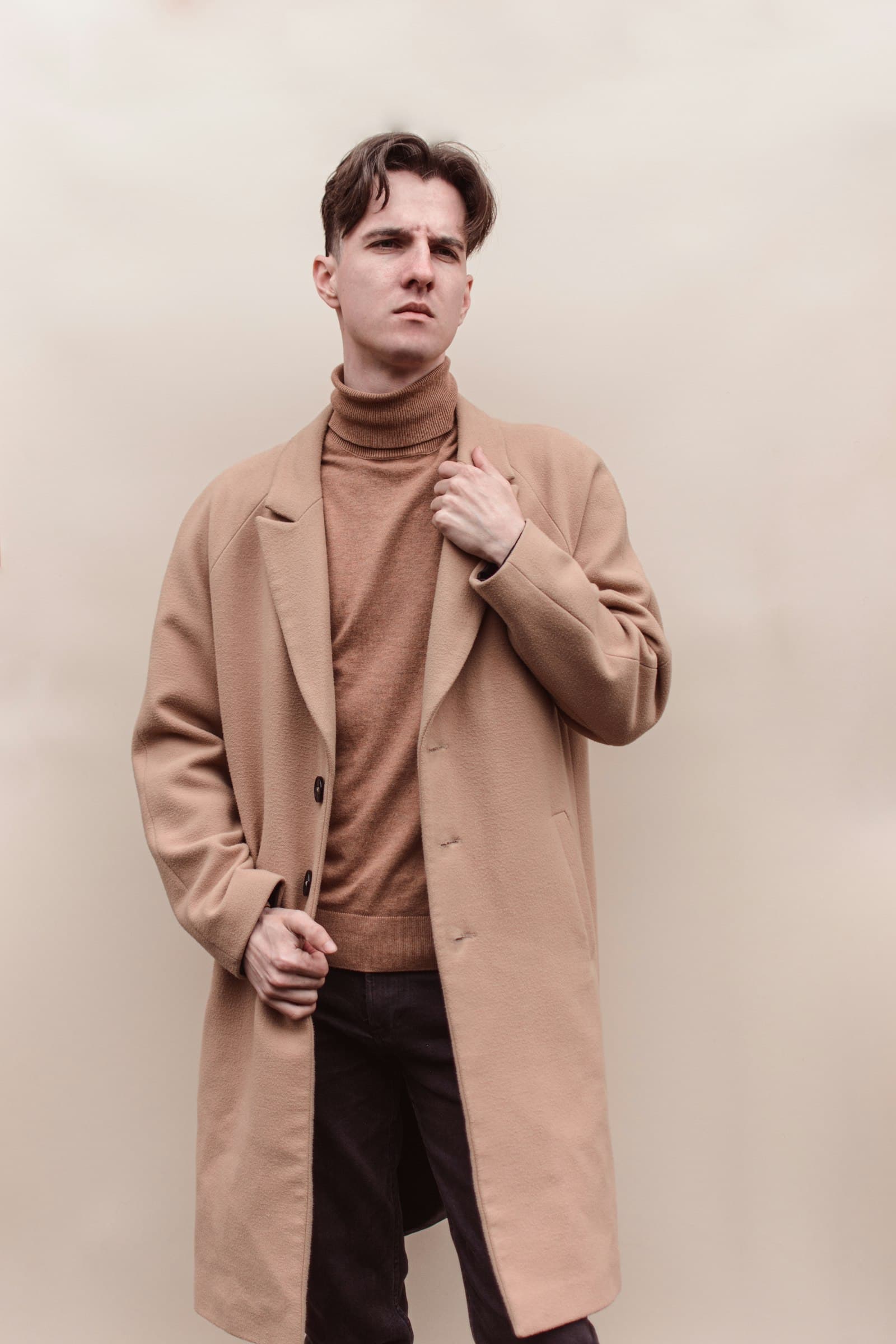 Man in brown coat standing