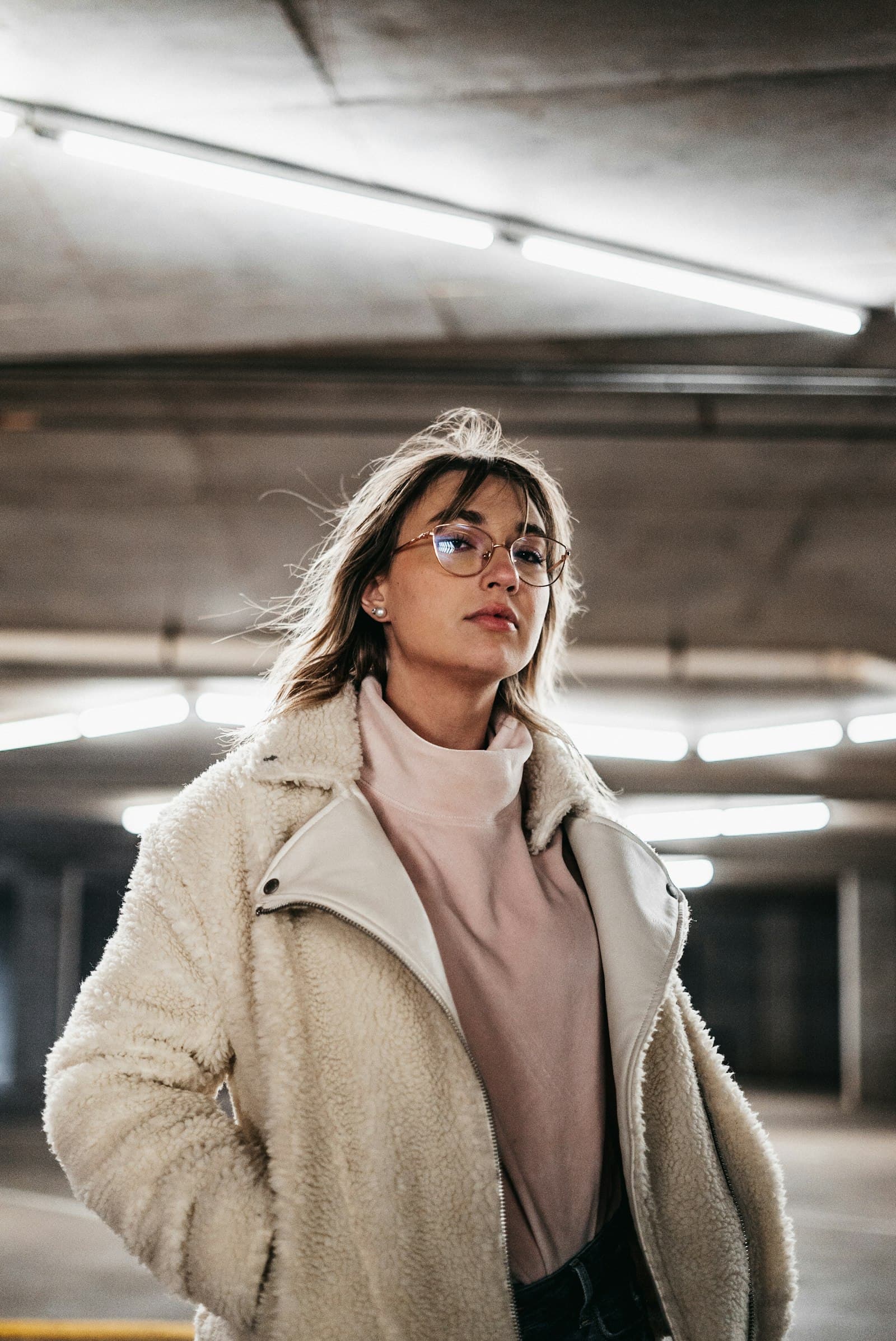 Woman in brown coat wearing black framed eyeglasses